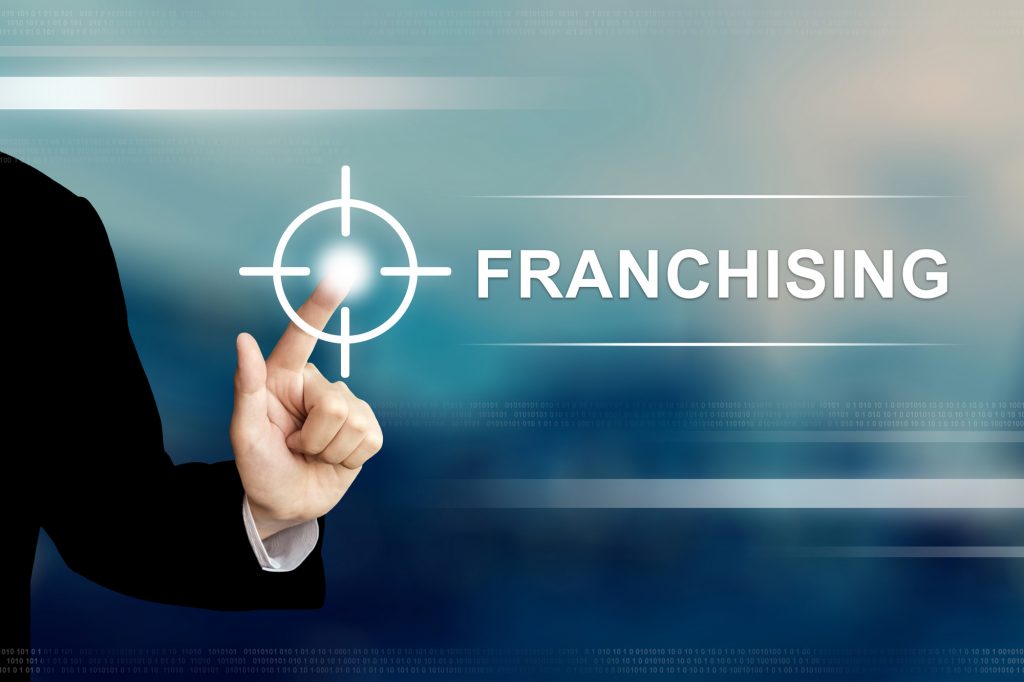 business hand pushing franchising