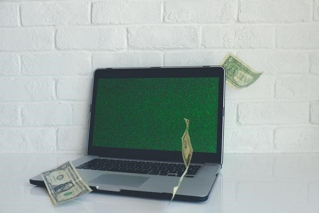 a laptop with a dollar bill