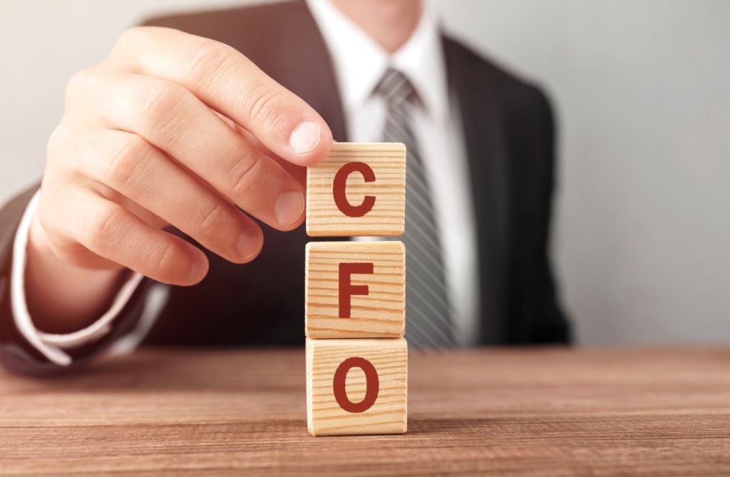 a man holding scrabble tiles that says cfo