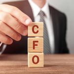 a man holding scrabble tiles that says cfo