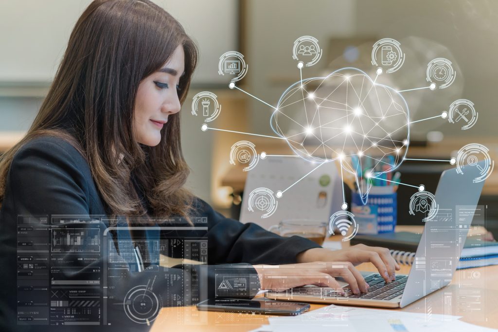 Mujer de negocios asiática con traje formal que trabaja con una computadora portátil para la forma poligonal del cerebro de una inteligencia artificial con varios íconos de la ciudad inteligente Internet de las cosas, IA y concepto de IOT de negocios