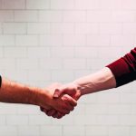 A customer and a business owner shaking hands