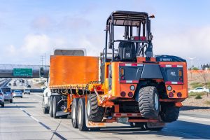 5 de enero de 2021 Antioch / CA / USA - Camión que transporta una carretilla elevadora MOFFETT M8 NX en la autopista